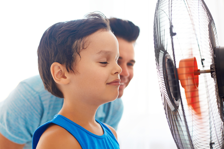 Egy fiú és az apja egy ventilátor előtt állva