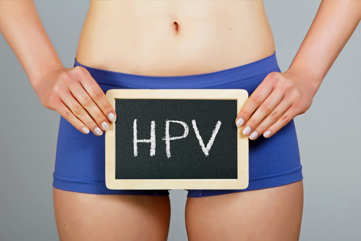 Nő kezében egy HPV feliratú táblával